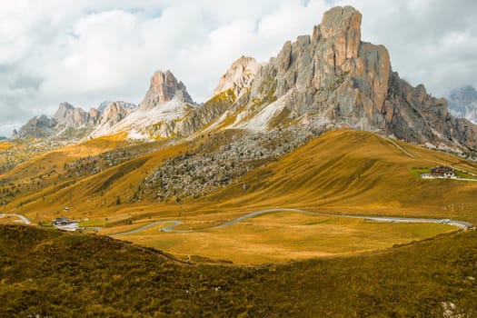 A lofty mountain range covered by clouds on the slopes of the famous Giau Pass.