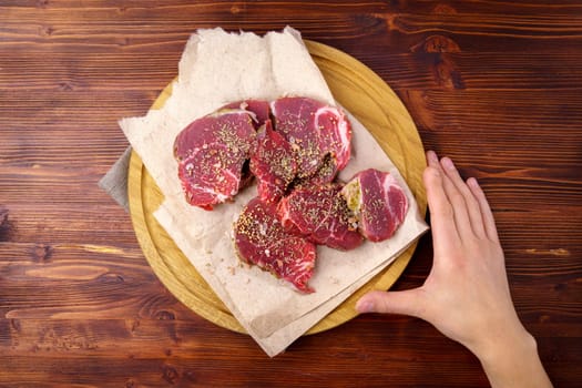 Raw Beef meat on old dark wooden table background, top view flat lay. Ingredients for delicious food.