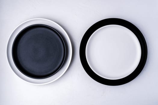 White and black food is an empty ceramic dish on a concrete background. Top View