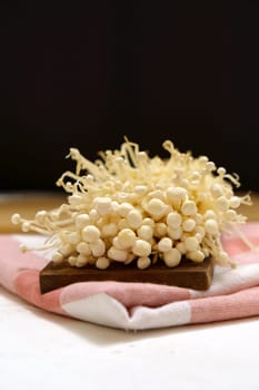 Enoki mushroom close up macro, Golden needle mushroom, used i food and salads. Vertical photo