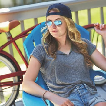 Cool as can be. an attractive young woman relaxing on a deck chair outdoors