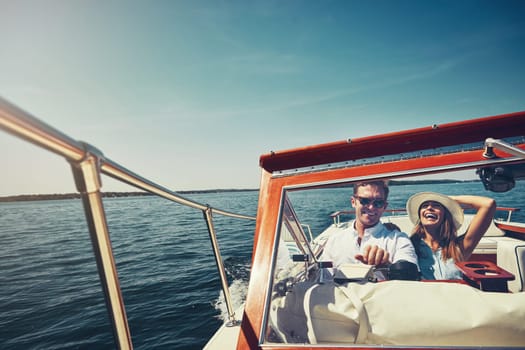 Take your boat and travel the world. an affectionate young couple sailing on the open seas in their yacht