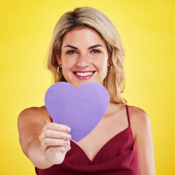 Portrait, heart and woman with wellness, emoji and happiness against a studio background. Face, female model and happy lady with a symbol for love, sign and support with smile, romantic and care.