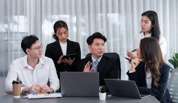 Harmony in office concept as business people analyzing dashboard paper together in workplace. Young colleagues give ideas at manager desk for discussion or strategy planning about project.