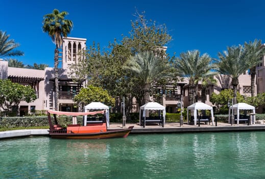 Small dhow docked by bank of waterway around Souk Madinat Jumeirah in Dubai