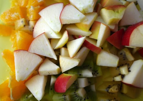 Fresh cut fruit parts. Apple, orange and green kiwi