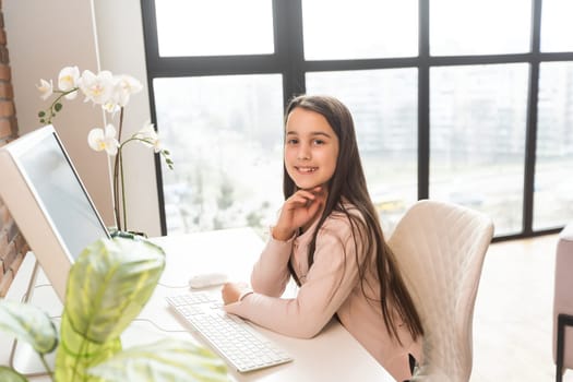 Smiling little Caucasian girl have video call distant class with teacher using laptop, happy small child wave greeting with tutor, study online on computer, homeschooling concept.