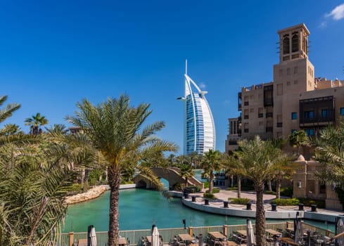 Restaurant along waterway around Souk Madinat Jumeirah in Dubai with iconic Arab hotel in background