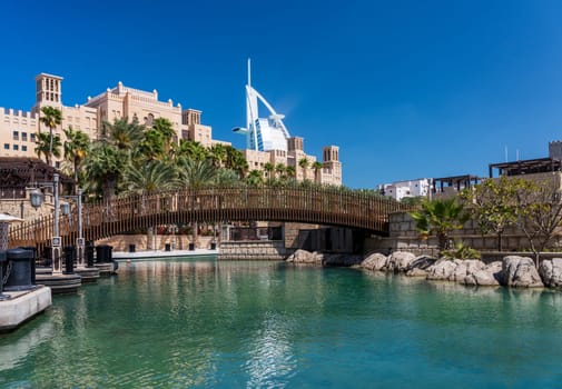 Restaurant along waterway around Souk Madinat Jumeirah in Dubai with iconic Arab hotel in background