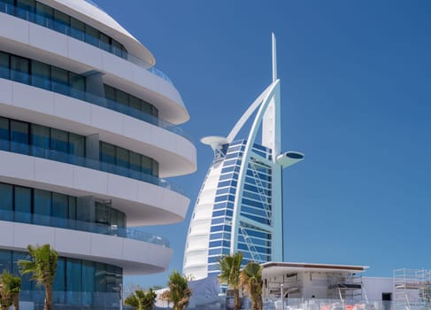 View of construction of Marsa al Arab hotel with Burj al Arab behind on coast of Dubai
