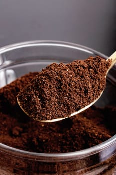 Ground coffee in a glass jar and spoon on the table