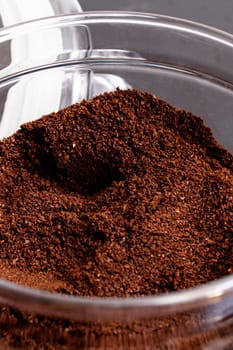 Ground coffee in a glass jar on the black wooden table