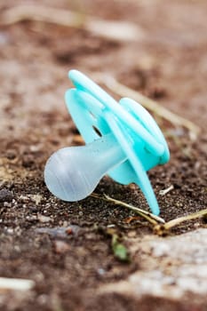 Lost blue baby nipple on the ground close up