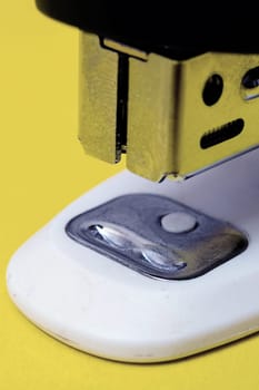 Office stapler on a yellow background close up
