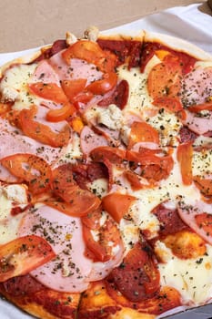 Pizza in a box on a wooden table, top view