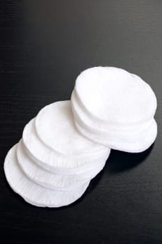 Cotton discs and buds black wooden table close up