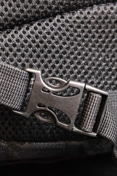 Plastic clasp on a black backpack close up