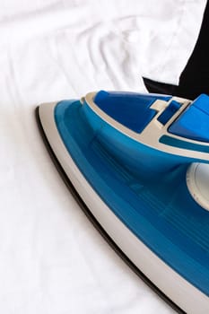 Blue iron on a white closethes close up, copy space