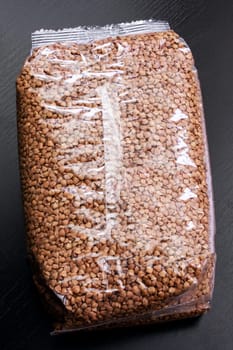 Buckwheat groats in a plastic bag on a wooden table