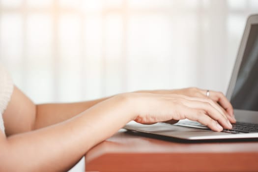 Asian woman's hand using a computer laptop for the concept of business, communication and media technology.