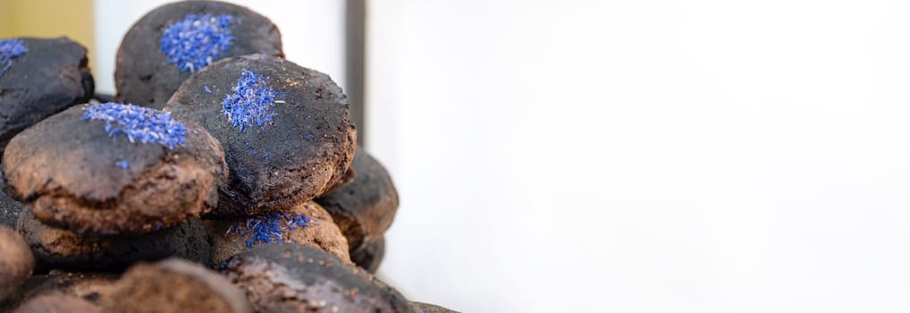 Black fresh homemade bread. A loaf of black rye bread on the counter of a bakery is cut into pieces close-up. Texture of black ecological bread.