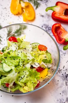 Vegetarian salad and sesame seeds with tomatoes and cucumber in a glass cup top view