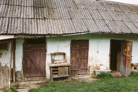 Old abandoned ruined house in dead village. Deserted and destroyed dwelling on farm yard. Neglected building countryside