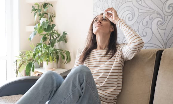 Head shot young caucasian woman using medical eyes drops suffering from dry eyes syndrome or curing ophthalmology disease at home. Unhealthy millennial lady having blurred eyesight, treating eyes