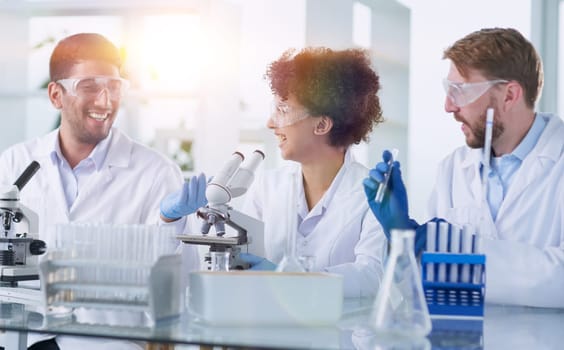 Team of Scientists Working Using Microscope, Analysing Microbiology Samples