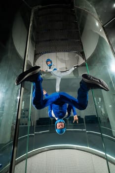 A man and a woman enjoy flying together in a wind tunnel. Free fall simulator.