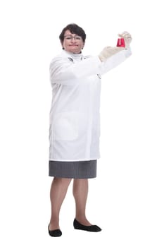 in full growth. senior female medic with a laboratory flask. isolated on a white background.