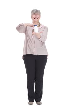 in full growth. smiling old lady showing hand sanitizer. isolated on a white background.