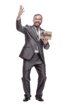 in full growth.happy business man with a gift box. isolated on a white background.