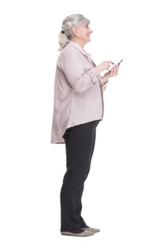 side view. casual elderly woman reading a message on her smartphone. isolated on a white background.
