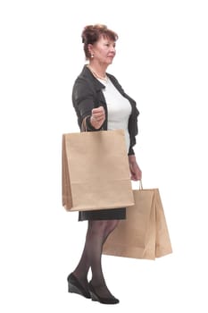 Side view portrait of happy senior woman posing with her shopping bag looking at camera and smiling