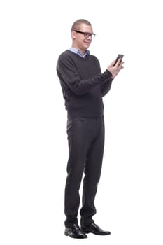 Smiling young man in glasses looking at camera and holding his smart phone isolated on white background