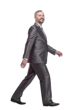in full growth. confident business man striding forward. isolated on a white background.