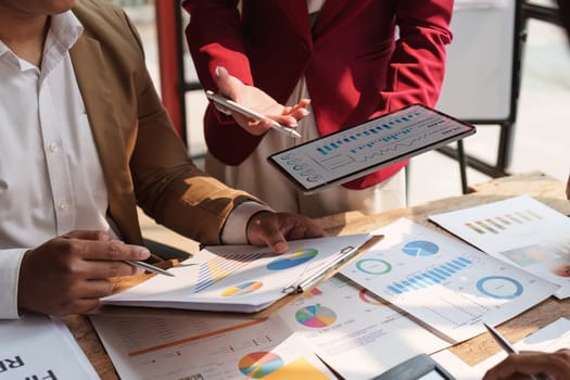 Close up of Diverse colleagues gather brainstorm discuss financial statistics at office meeting. finance, teamwork, Big data Graphs Charts concept.