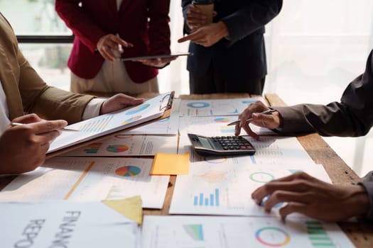 Close up of Diverse colleagues gather brainstorm discuss financial statistics at office meeting. finance, teamwork, Big data Graphs Charts concept.