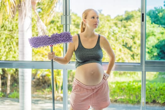 Pregnant woman washes the floor and is tired. Tired pregnant woman having pain in back while she is cleaning her house.