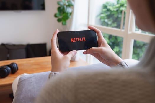 CHIANG MAI, THAILAND APR 21, 2023: Netflix logo on iPhone screen. Netflix is an international leading subscription service for watching TV episodes and movies.