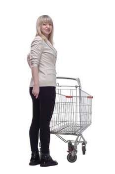 side view. blonde woman with a shopping cart looking at you . isolated on a white background.