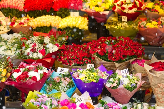 Colorful roses bouquet display in front of flower shop. Flower arrangements for sale at local market. Flowers on sale before mother day, 8 march.