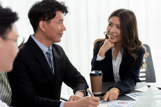 Harmony in office concept as business people analyzing dashboard paper together in workplace. Young colleagues give ideas at manager desk for discussion or strategy planning about project.