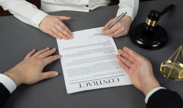 Lawyer signing contract, professional lawyer in law firm library drafting legal document or contract agreement ensuring lawful protection for client's dispute as fairness advocate concept. Equilibrium