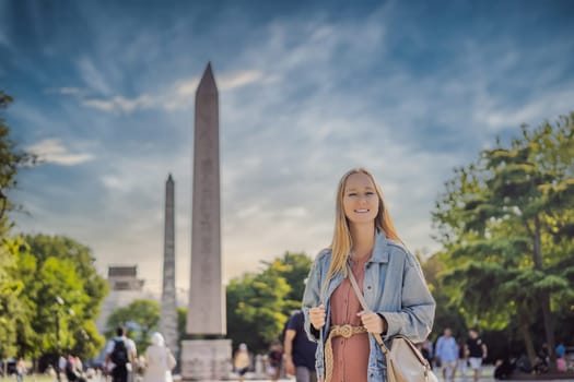 Woman Tourist in Istanbul against the background of Obelisk of Theodosius is the Ancient Egyptian obelisk of Pharaoh Thutmose III places in the Hippodrome of Constantinople, Turkey. Theodosius Dikilitasi.