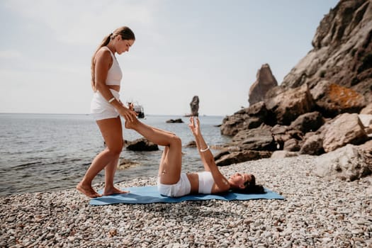 Woman sea yoga. Back view of free calm happy satisfied woman with long hair standing on top rock with yoga position against of sky by the sea. Healthy lifestyle outdoors in nature, fitness concept.