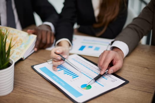 Teamwork. Close-up of business people discussing something while looking at the graphs and charts