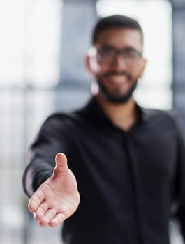 smiling businessman reaching out for a handshake