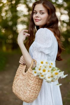 portrait of a beautiful red-haired woman with a wicker bag in her hands, smiling, enjoying a walk in the park. High quality photo